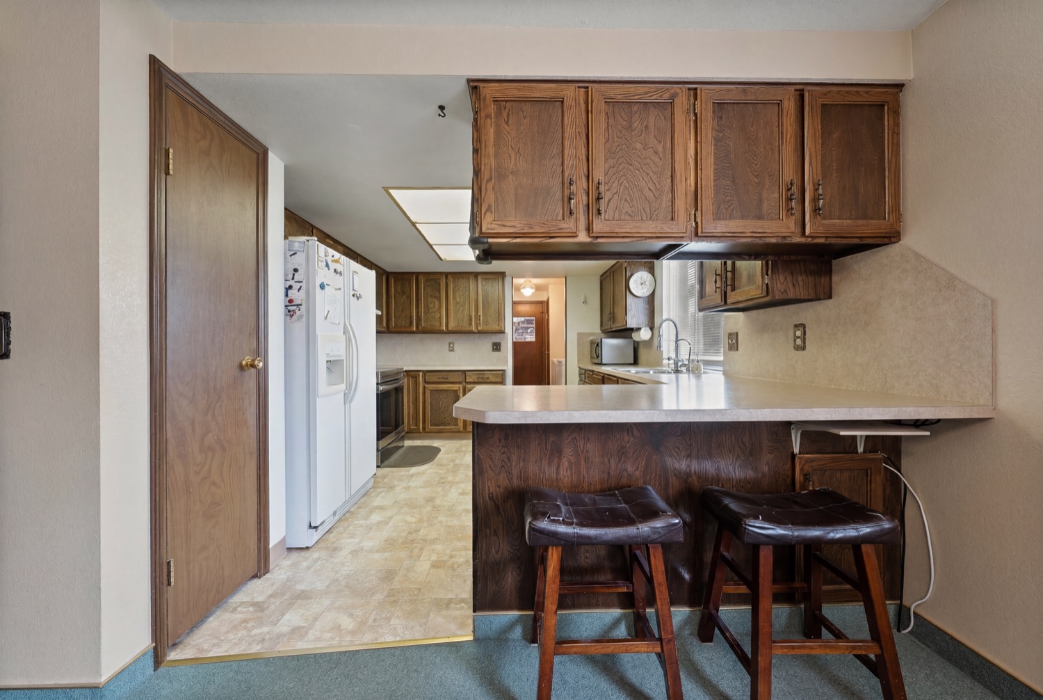 Kitchen with wood cabinetry and breakfast bar seating