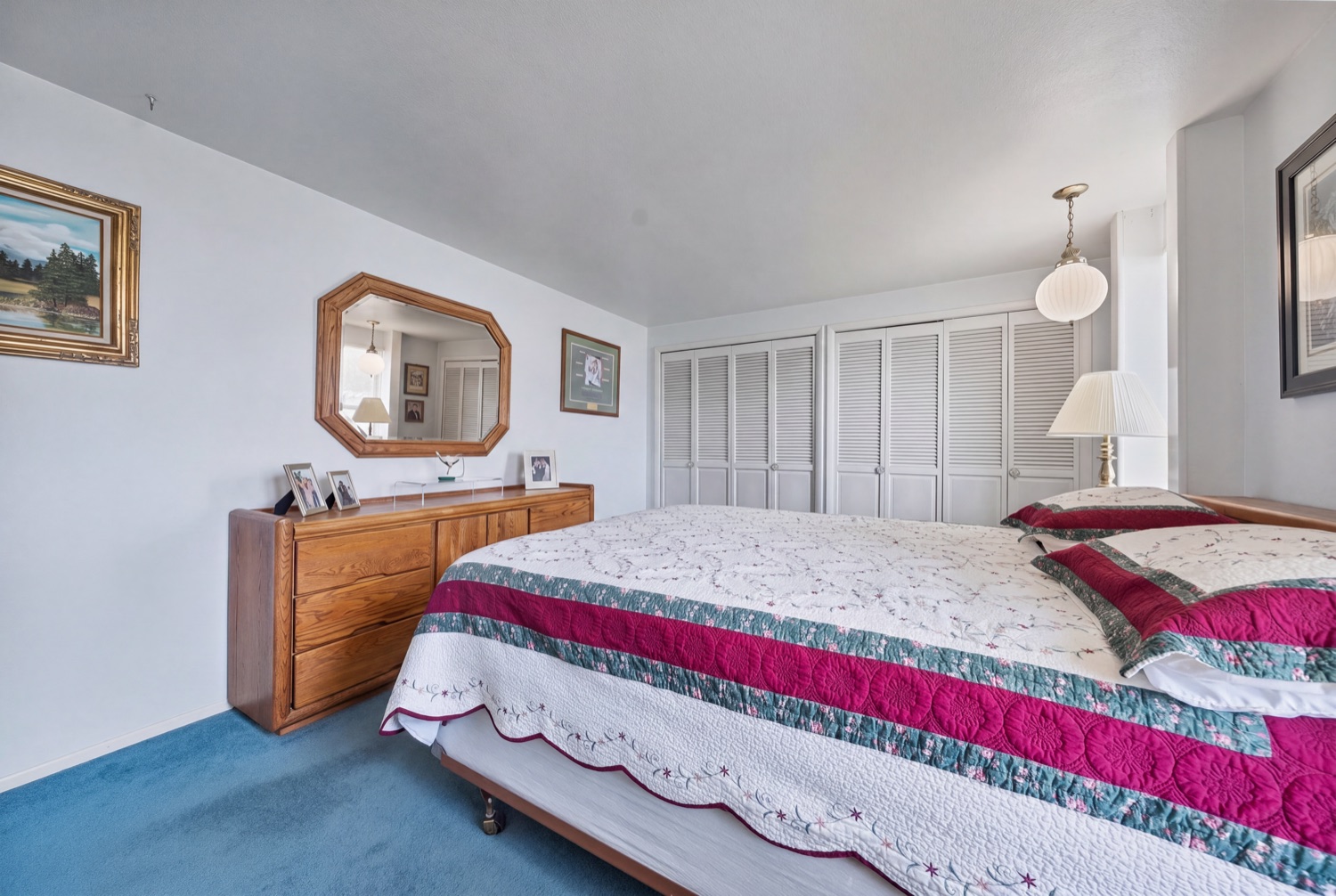 Primary bedroom with dresser and large windows
