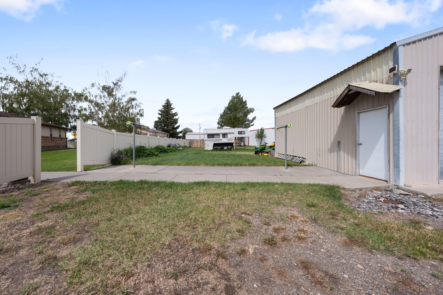 Shop and rear yard with concrete apron and privacy fence